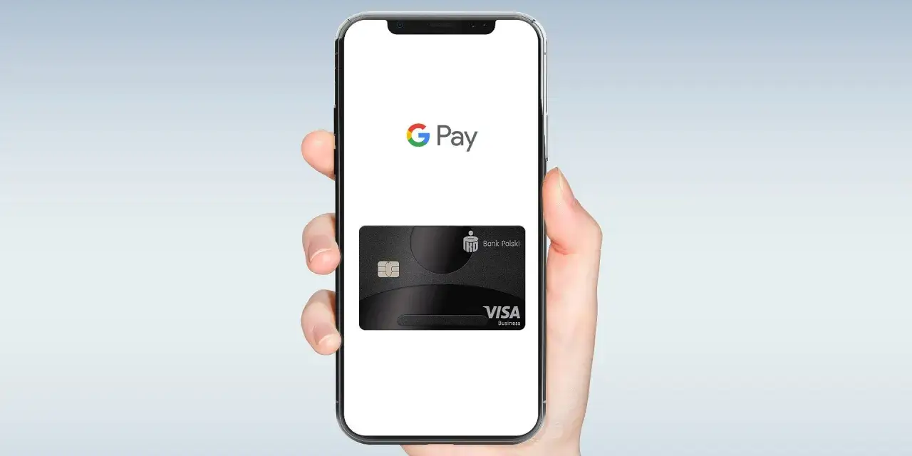 Dłoń trzyma smartfon z logo Google Pay i wirtualną kartą Visa Banku Polskiego. Płać wygodnie, bez fizycznej karty.