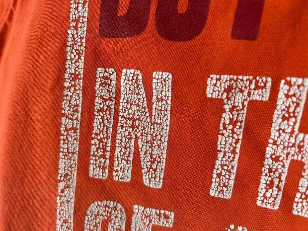 zniszczona koszulka z popękanym nadrukiem po praniu