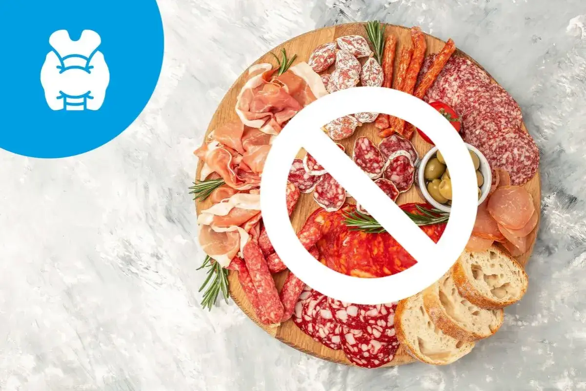 Talerz wędlin z zakazem spożywania. Symbol tarczycy i wysokie TSH sugerują dietę przy niedoczynności tarczycy.