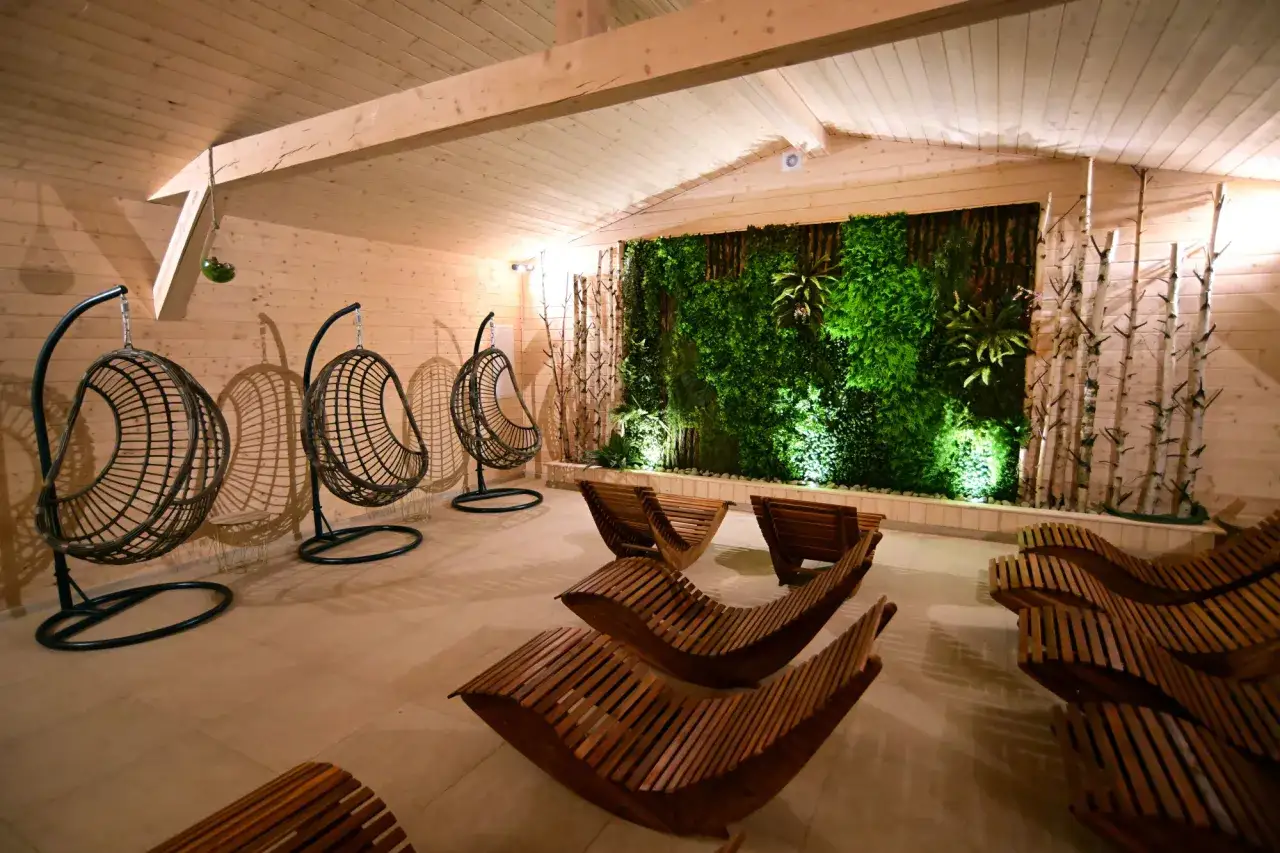 Relaks w klimatycznym day spa Zakopane. Huśtawki, leżaki i zielona ściana tworzą oazę spokoju.