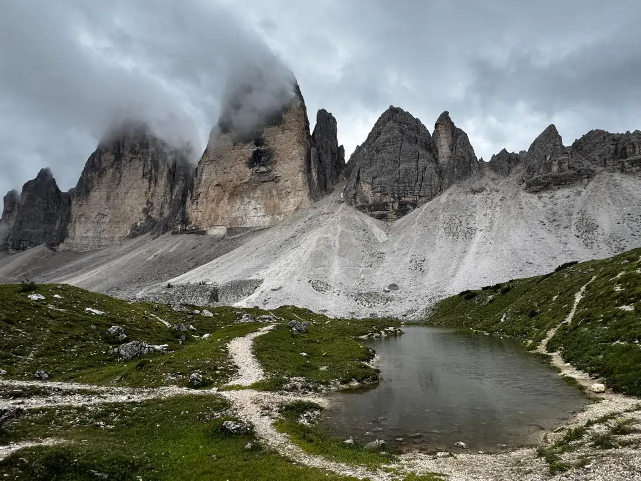 Mgliste szczyty Tre Cime di Lavaredo nad jeziorem.