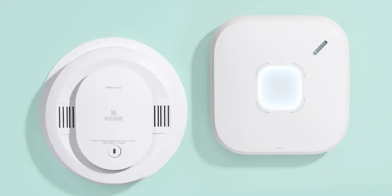 Dwa białe czujniki dymu: okrągły Kidde z napisem 