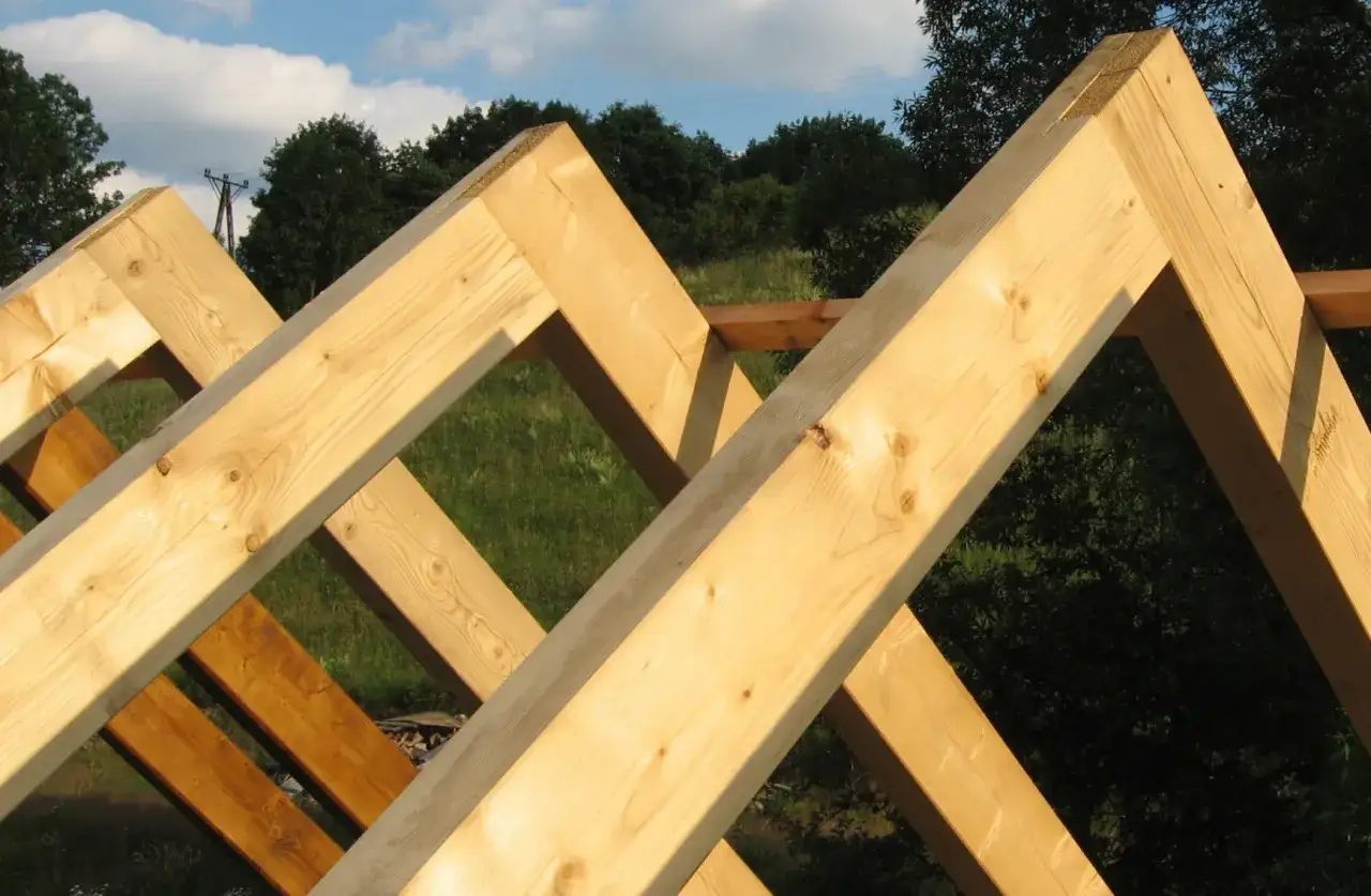 Drewniane krokwie tworzą konstrukcję dachu, ukazując staranne łączenie krokwi w szczycie.