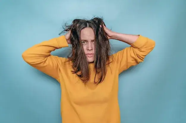 Kobieta zaniepokojona, trzymająca się za głowę