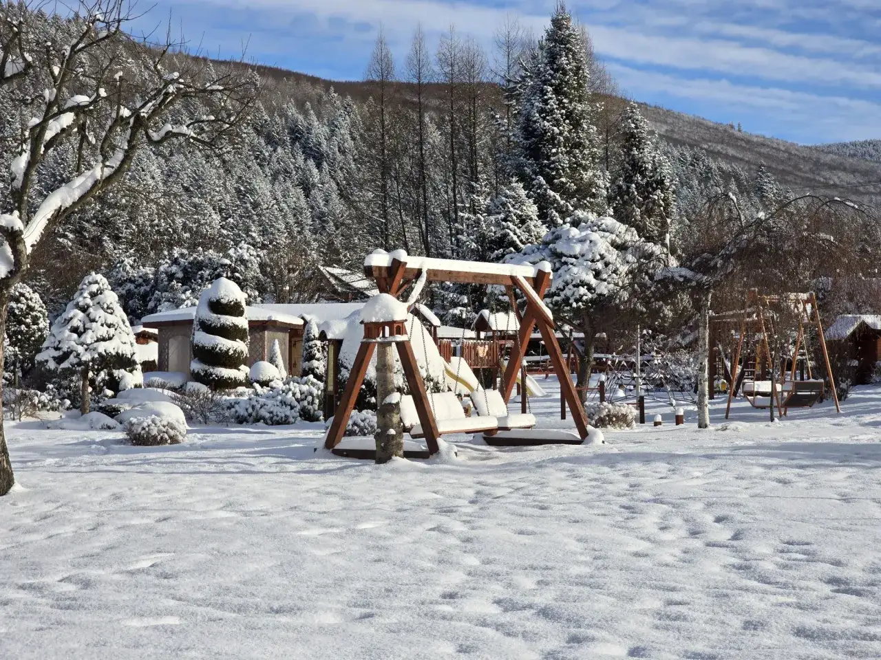 Zimowy krajobraz z huśtawkami i domkami, idealne miejsce na babia g&oacute;ra gdzie nocleg.