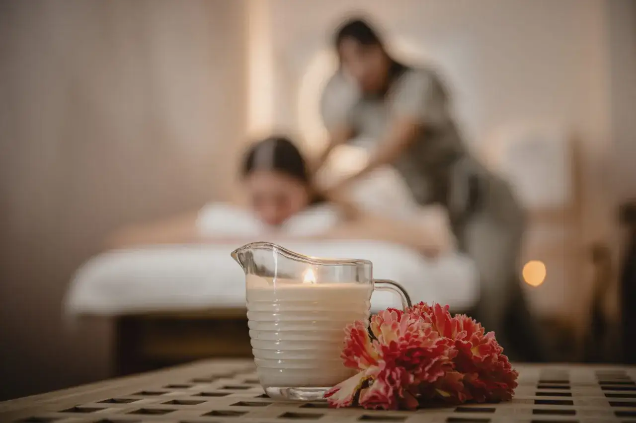 Relaks w spa: świeca, kwiaty i masaż pleców. Dowiedz się, jak masować plecy, by poczuć ulgę.