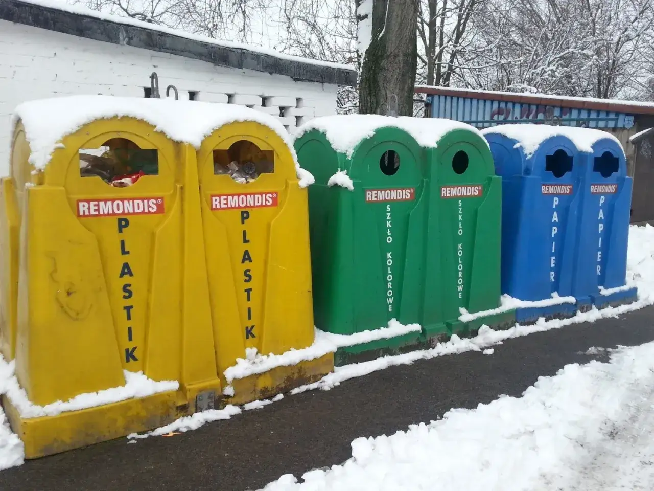 Śnieg na koszach na śmieci w Zgierzu. Żółte na plastik, zielone na szkło, niebieskie na papier.