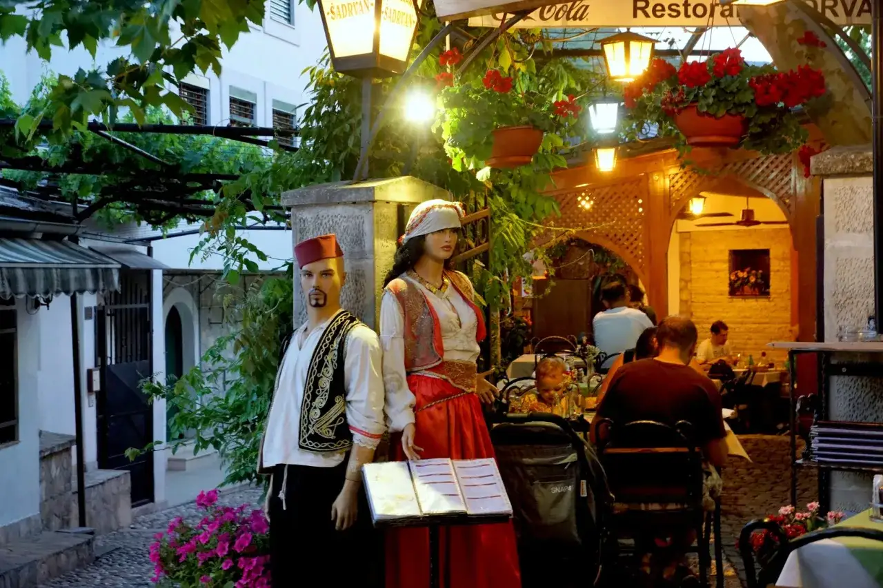 Manekiny w strojach ludowych przed restauracją w Sarajewie. Ceny w lokalnych restauracjach są przystępne.