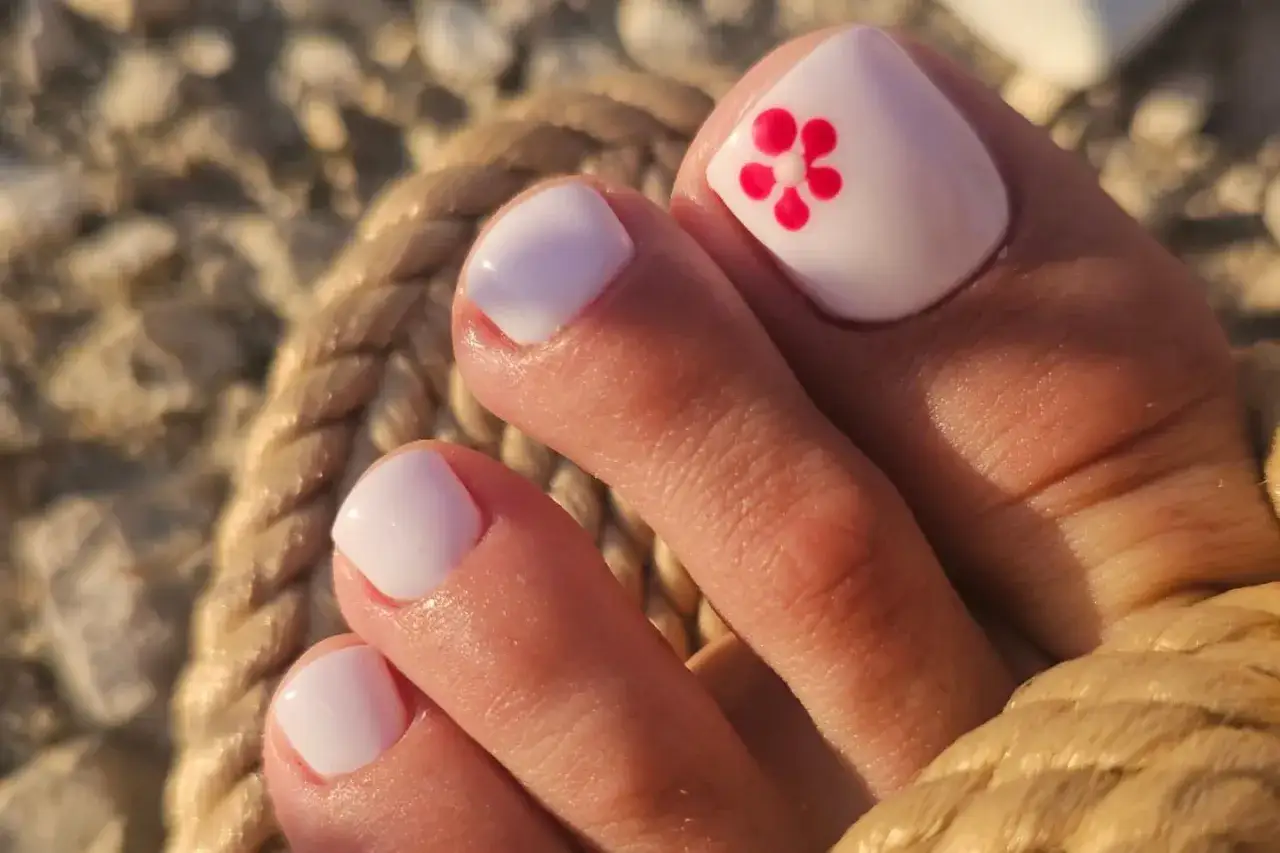 Letnie słońce i **pedicure hybrydowy na lato** z uroczym kwiatkiem. Idealny na wakacje!