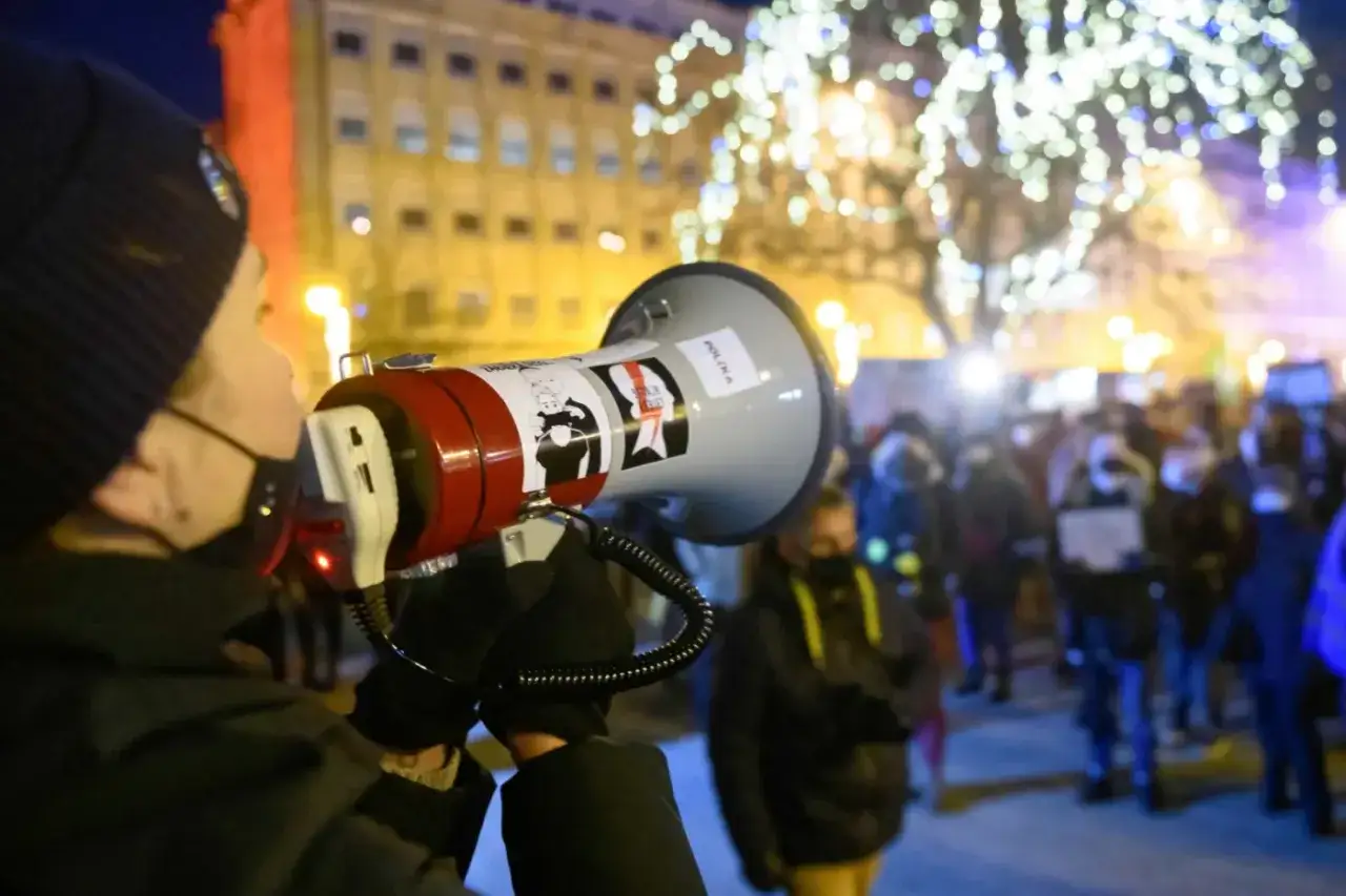 Osoba z megafonem na demonstracji. Słowa 