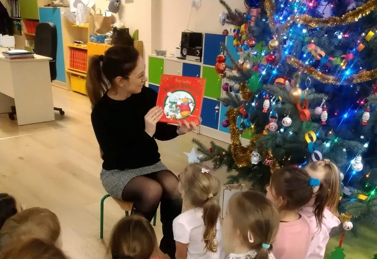 dziecko czytające książkę o przedszkolu, rodzic z dzieckiem oglądający przedszkole