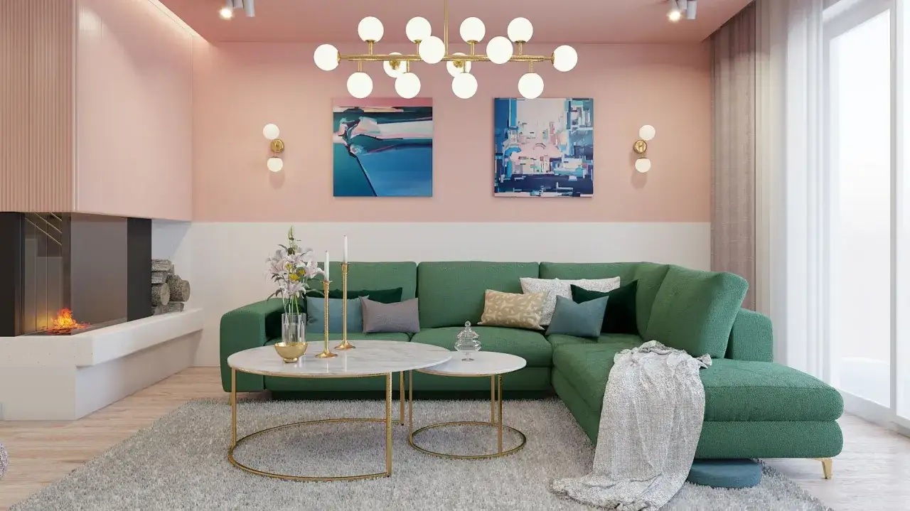 Przytulny salon z kanapą w kolorze butelkowej zieleni, na tle ścian w odcieniach pudrowego r&oacute;żu. Kominek i nowoczesne obrazy dopełniają aranżację.