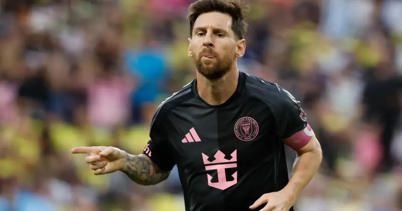 Piłkarz Lionel Messi w czarnej koszulce z różowymi detalami, wskazujący palcem. Ile bramek ma Messi? Tego nie wiemy, ale na pewno wiele!