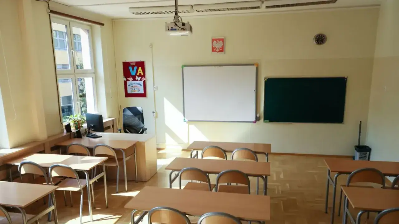 Pusta klasa, ławki czekają na uczniów, kiedy nauczyciel nie może przeprowadzić lekcji.