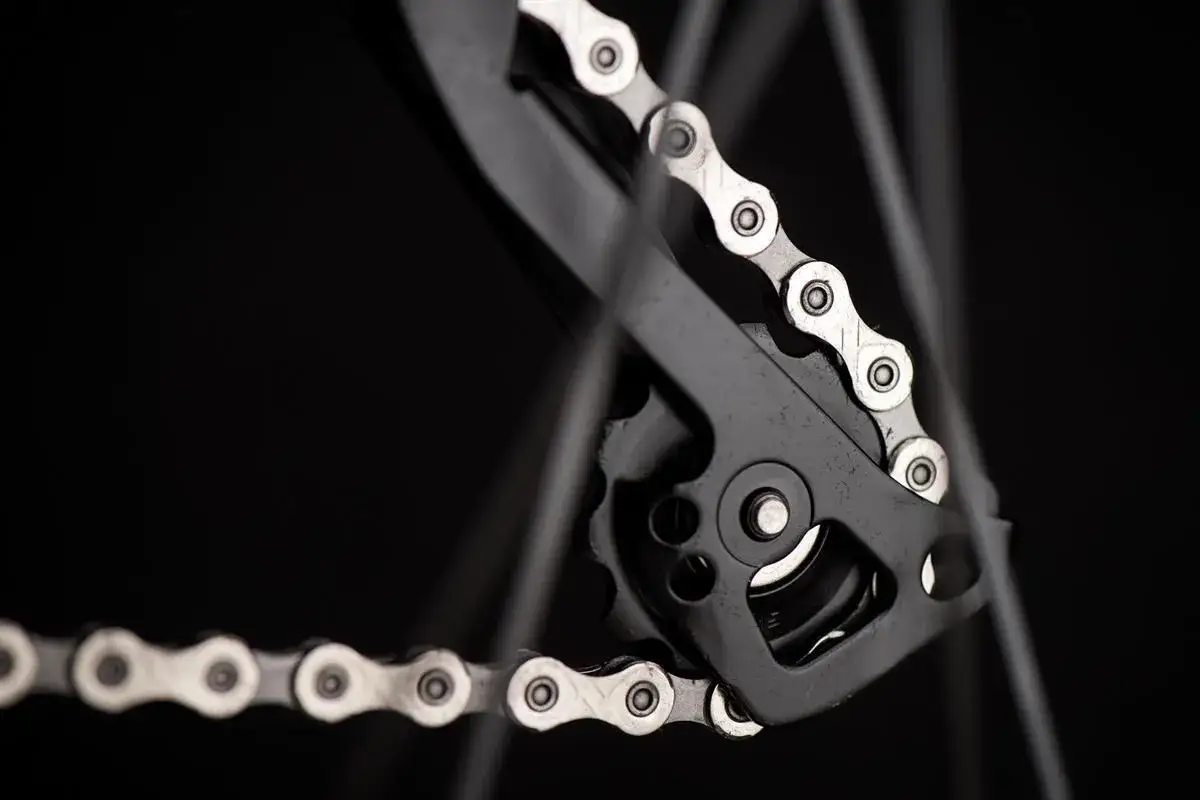 Zbliżenie na przerzutkę rowerową i łańcuch. Dowiedz się, jak dobrać długość łańcucha rowerowego, by wszystko działało płynnie.