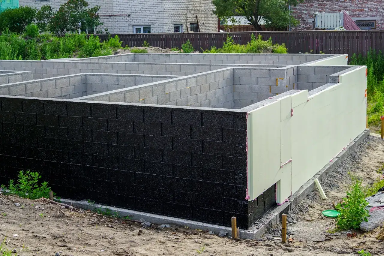 Fundamenty z bloczków betonowych, częściowo ocieplone styropianem. Budowa domu w toku.