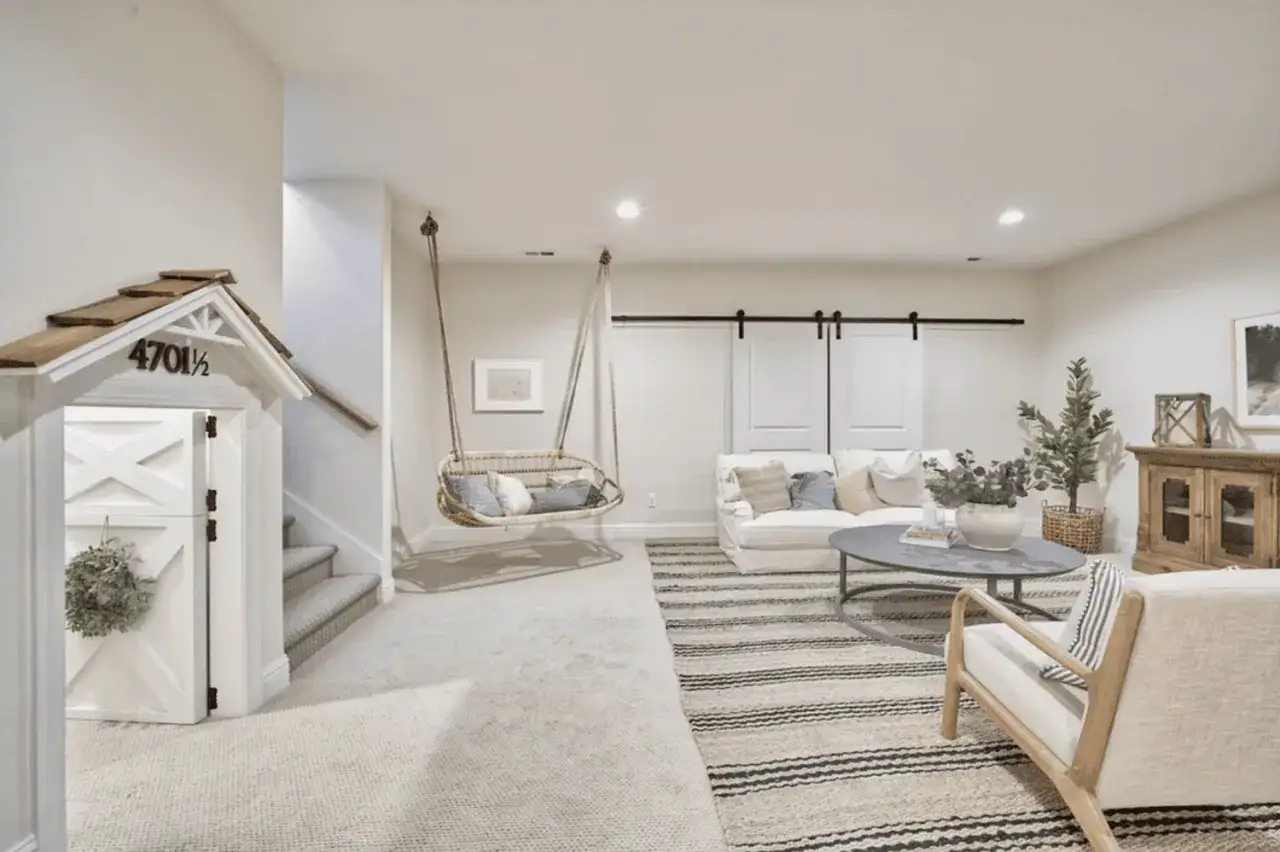 Piwnica inspiracje: przytulny kącik z huśtawką, kanapą i drzwiami jak z bajki.