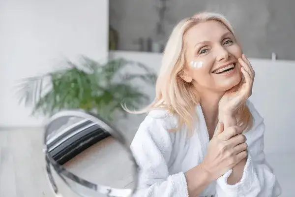 Kobieta dbająca o sk&oacute;rę twarzy w średnim wieku