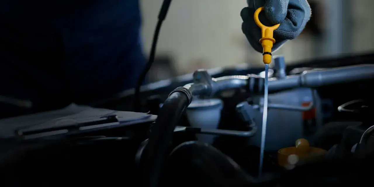 Serwis olejowy samochodu, mechanik wymienia olej