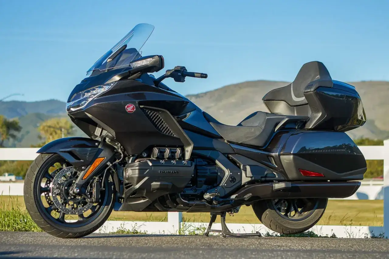 Czarny motocykl Honda Gold Wing, idealny jako dobry motor szosowo turystyczny, gotowy na długie podróże.