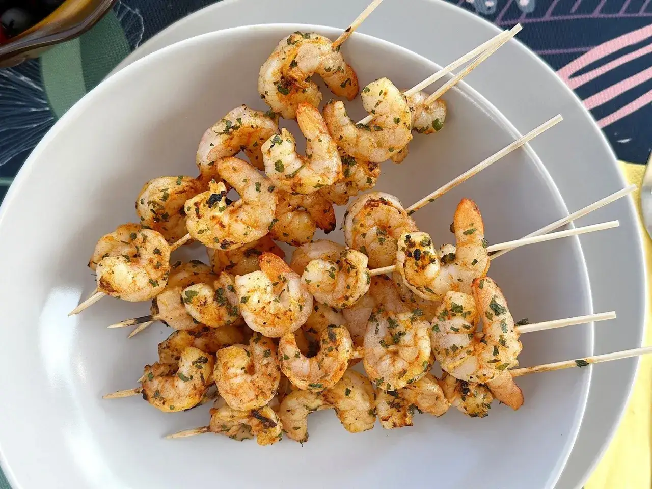 Krewetki z grilla, aromatyczne i soczyste, podane na białym talerzu.