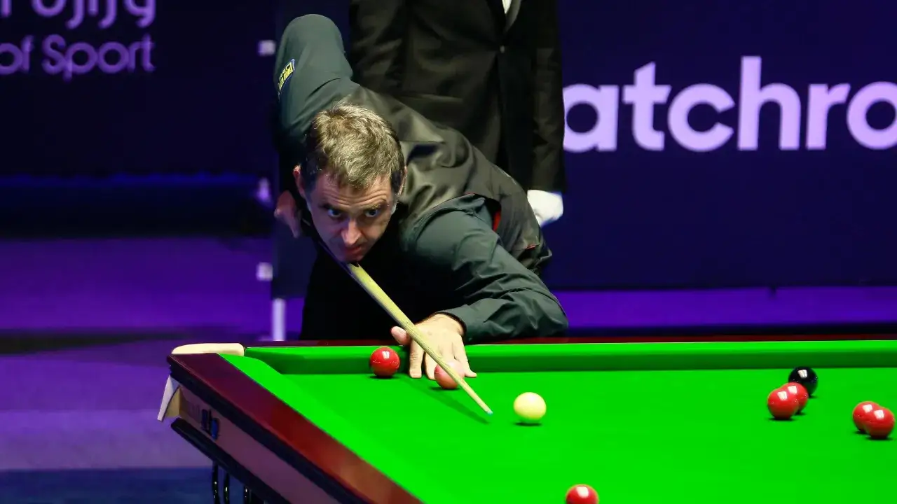 Ronnie O'Sullivan w akcji, skupiony na grze w snookera. Jego sportowa pasja widoczna w każdym ruchu.