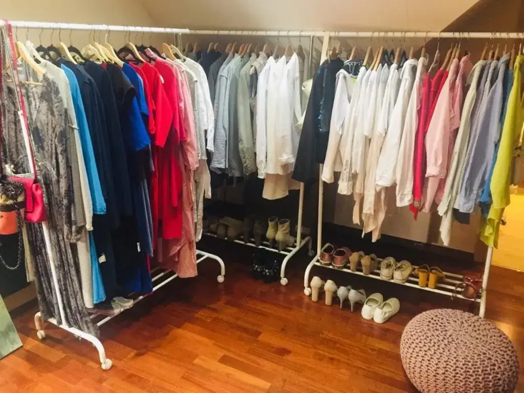 Kobieta przeglądająca ubrania w szafie, zorganizowana szafa