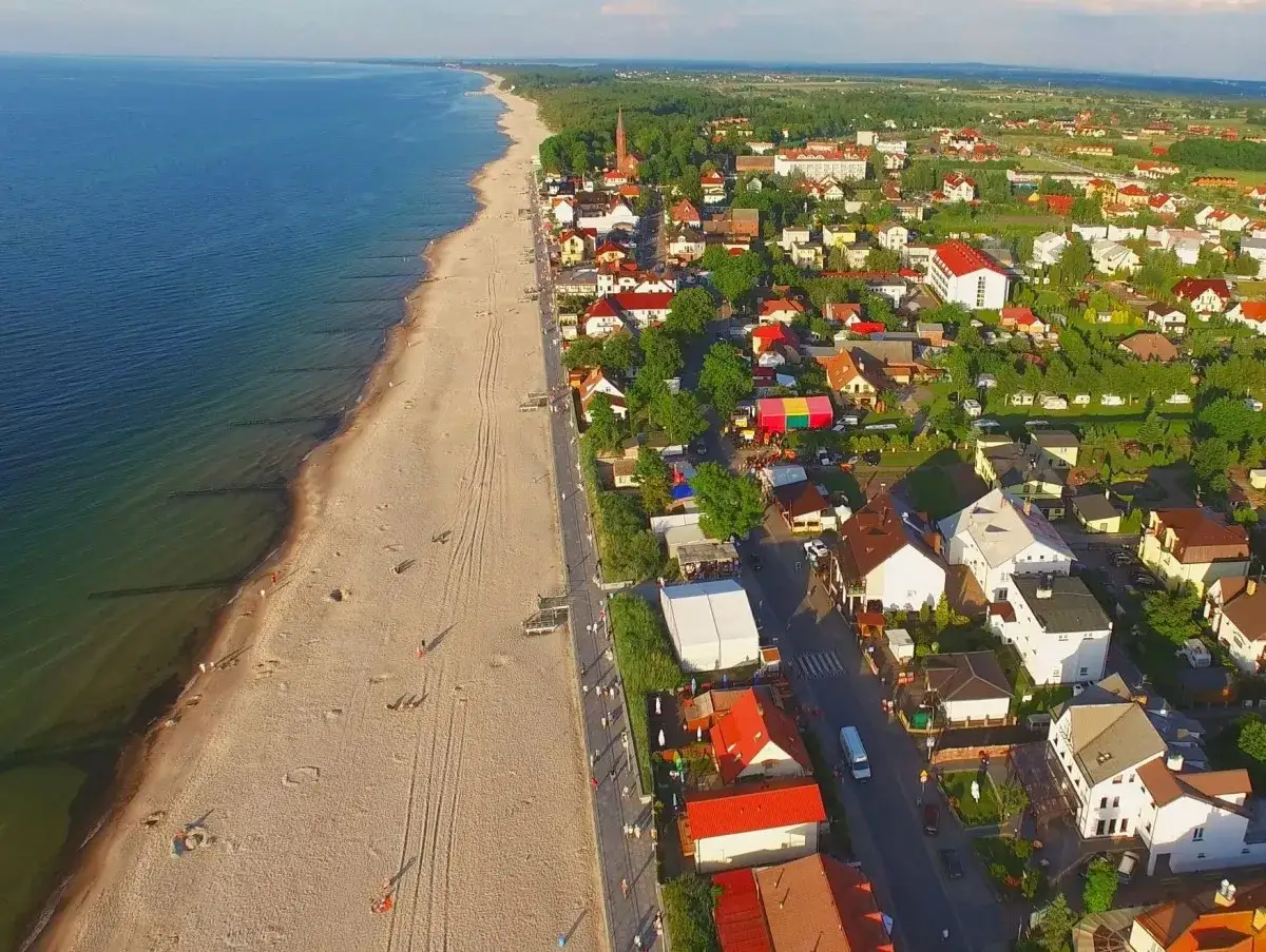 Malowniczy dom przy plaży w Sarbinowie, z widokiem na morze i urokliwe nadmorskie zabudowania.