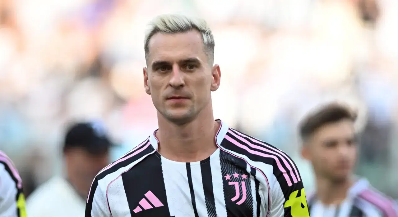 Piłkarz w koszulce Juventusu, z blond włosami. Fani zastanawiają się, ile zarabia Arkadiusz Milik.