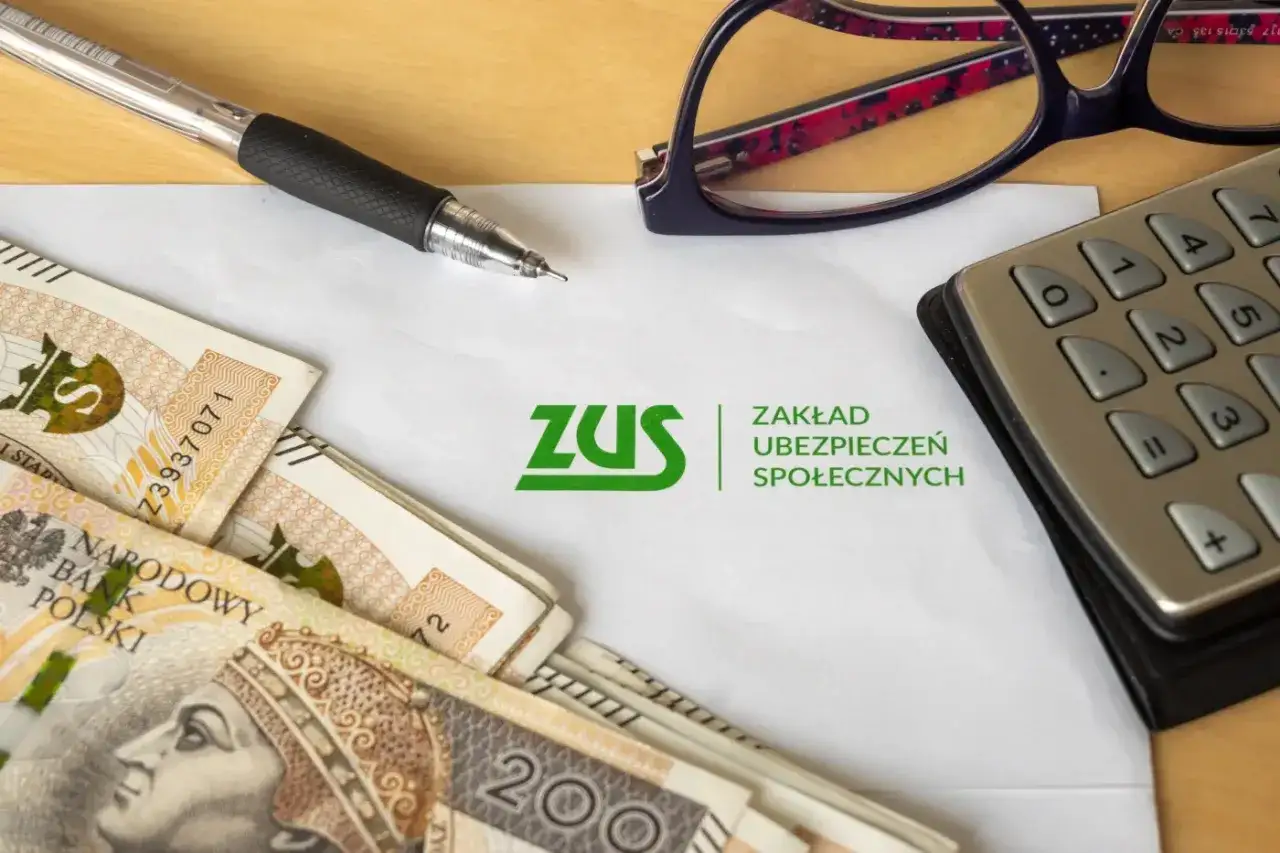 Pióro, okulary, kalkulator i pieniądze leżą obok dokumentu z logo ZUS. Chcesz wiedzieć, jak sprawdzić lata pracy w ZUS PUE?