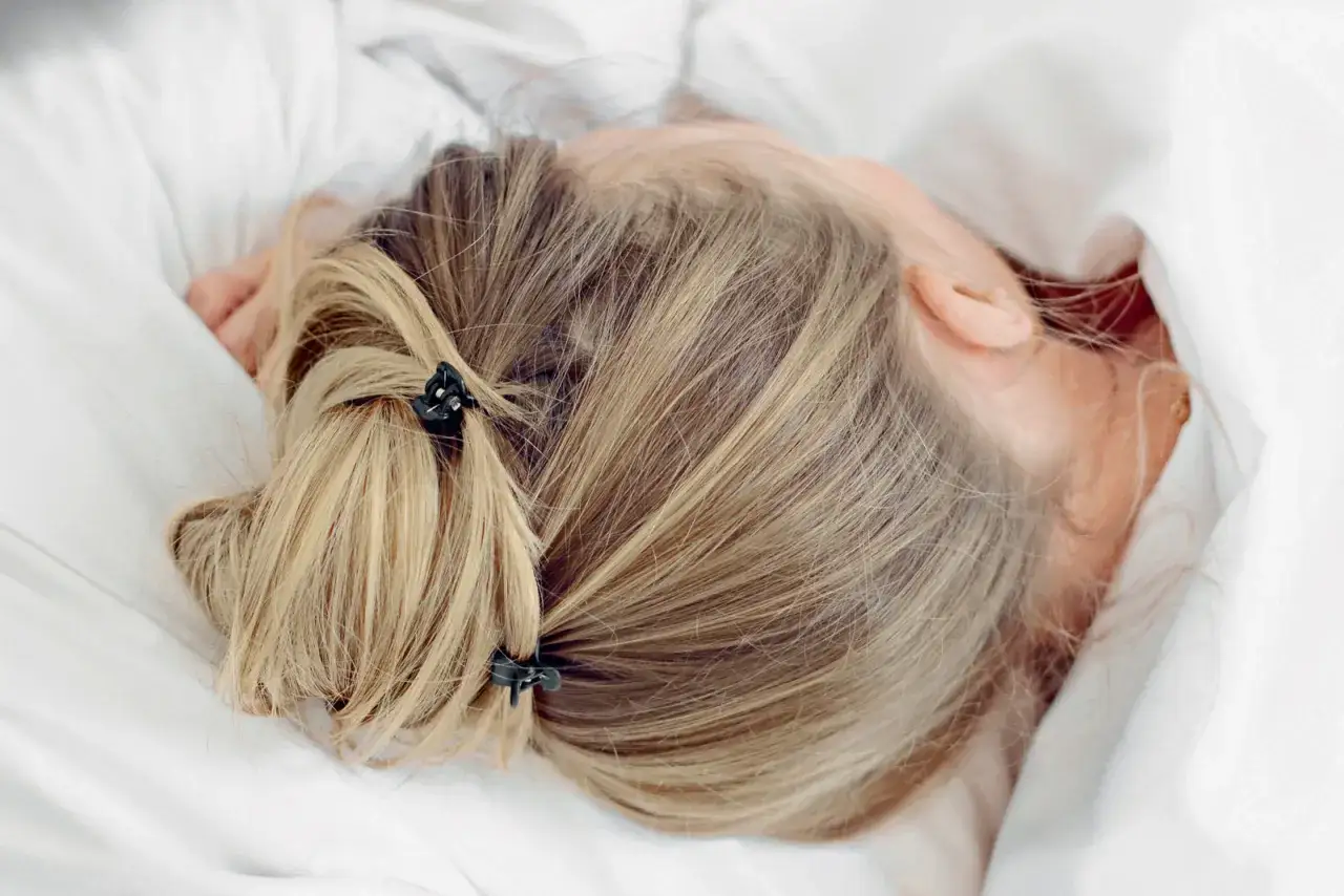 Długie, blond włosy spięte w dwa kucyki, idealne fryzury na noc do spania, by uniknąć splątania.