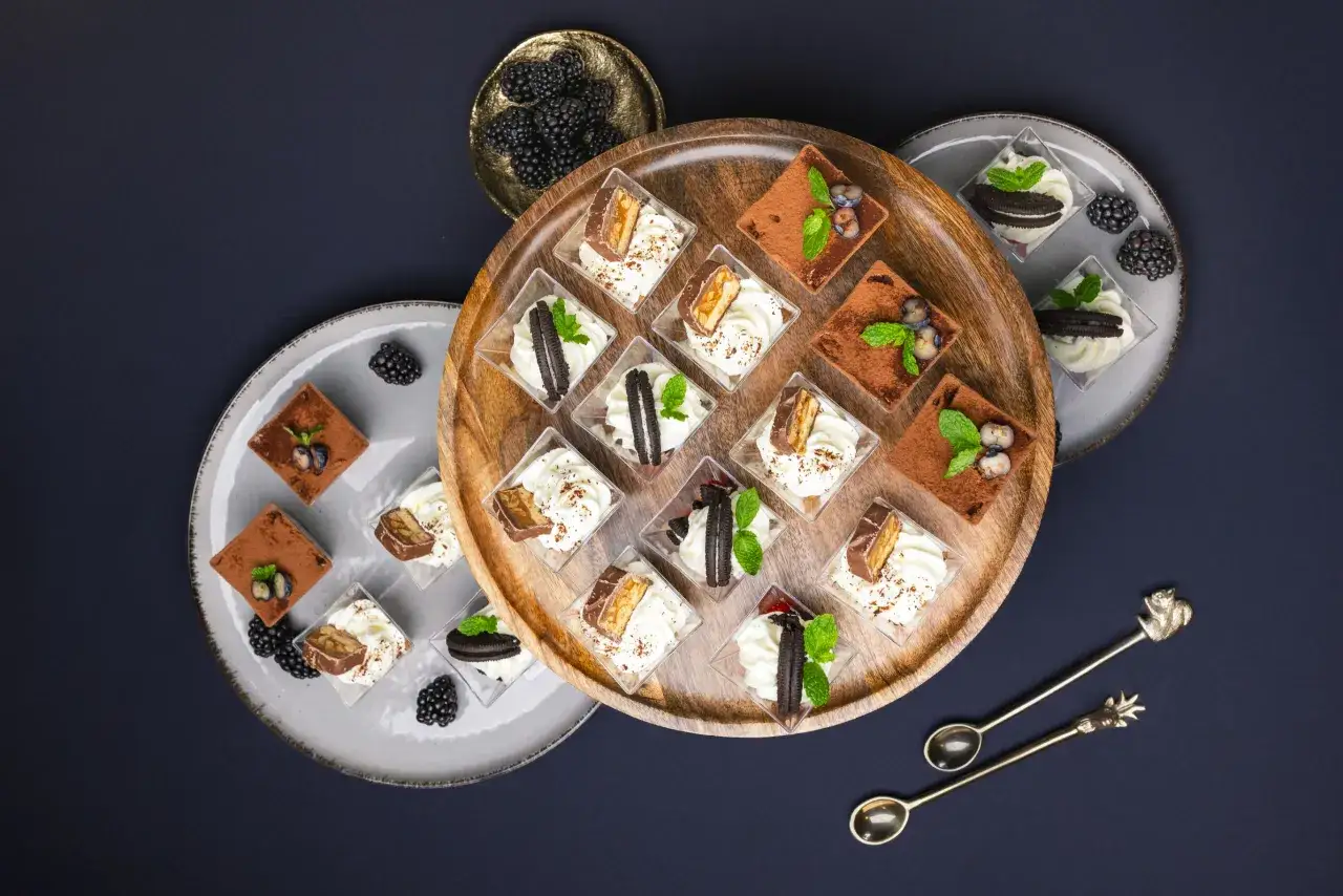 Eleganckie desery w pucharkach: tiramisu, z batonikiem i ciasteczkiem. Idealne na przyjęcie, zastanawiasz się, ile kosztuje catering na urodziny?