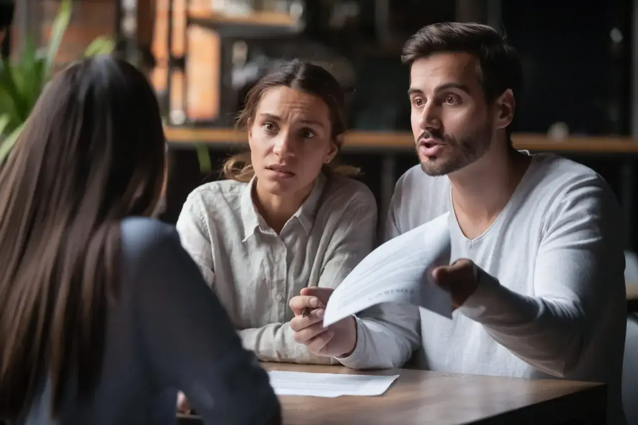 Ludzie składający reklamację w biurze podr&oacute;ży