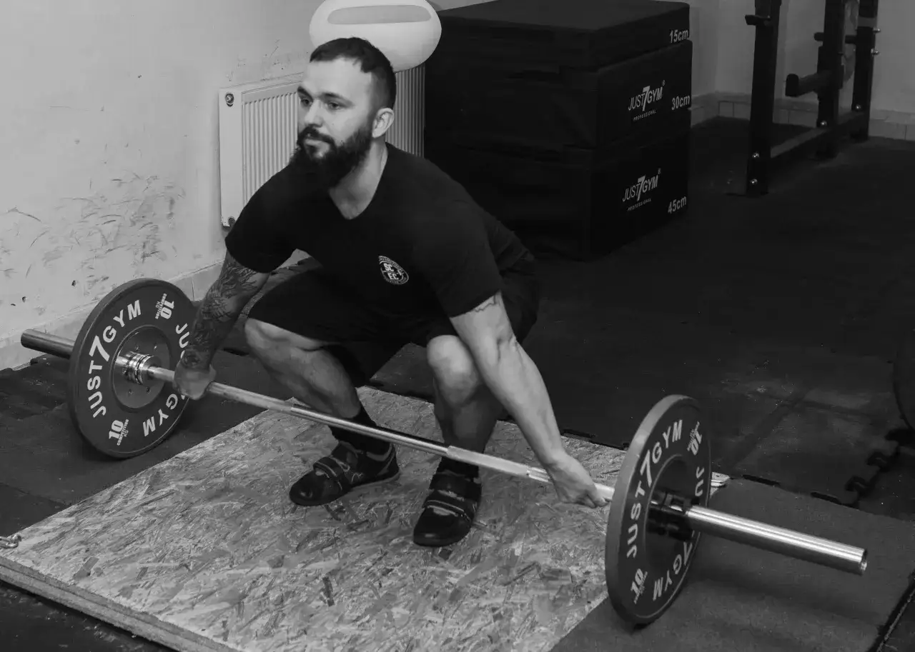 sportowiec podnoszący ciężary z prawidłową techniką oddychania