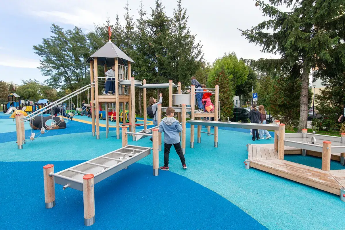 Nowy plac zabaw dla dzieci kiedy otwarcie? Dzieci bawią się na nowoczesnych konstrukcjach, zjeżdżalniach i huśtawkach.