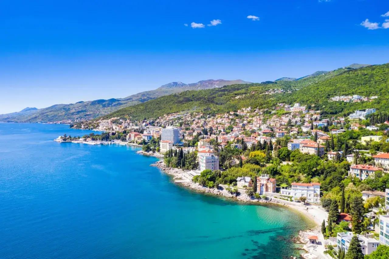 Malownicze chorwackie miasta nad Adriatykiem, z zabudową wciśniętą w zielone wzgórza, rozciągają się wzdłuż turkusowego morza.