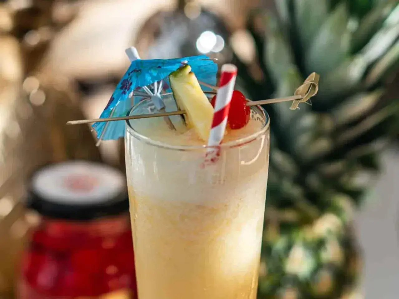 Orzeźwiający drink pina colada z ananasem, wiśnią i parasolką. Idealny na wakacje!