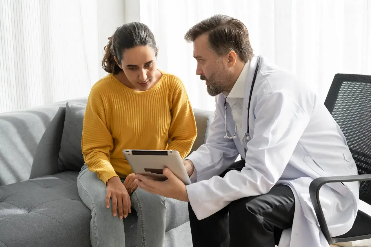 Lekarz omawia z pacjentką szczepienia do Japonii, pokazując informacje na tablecie.