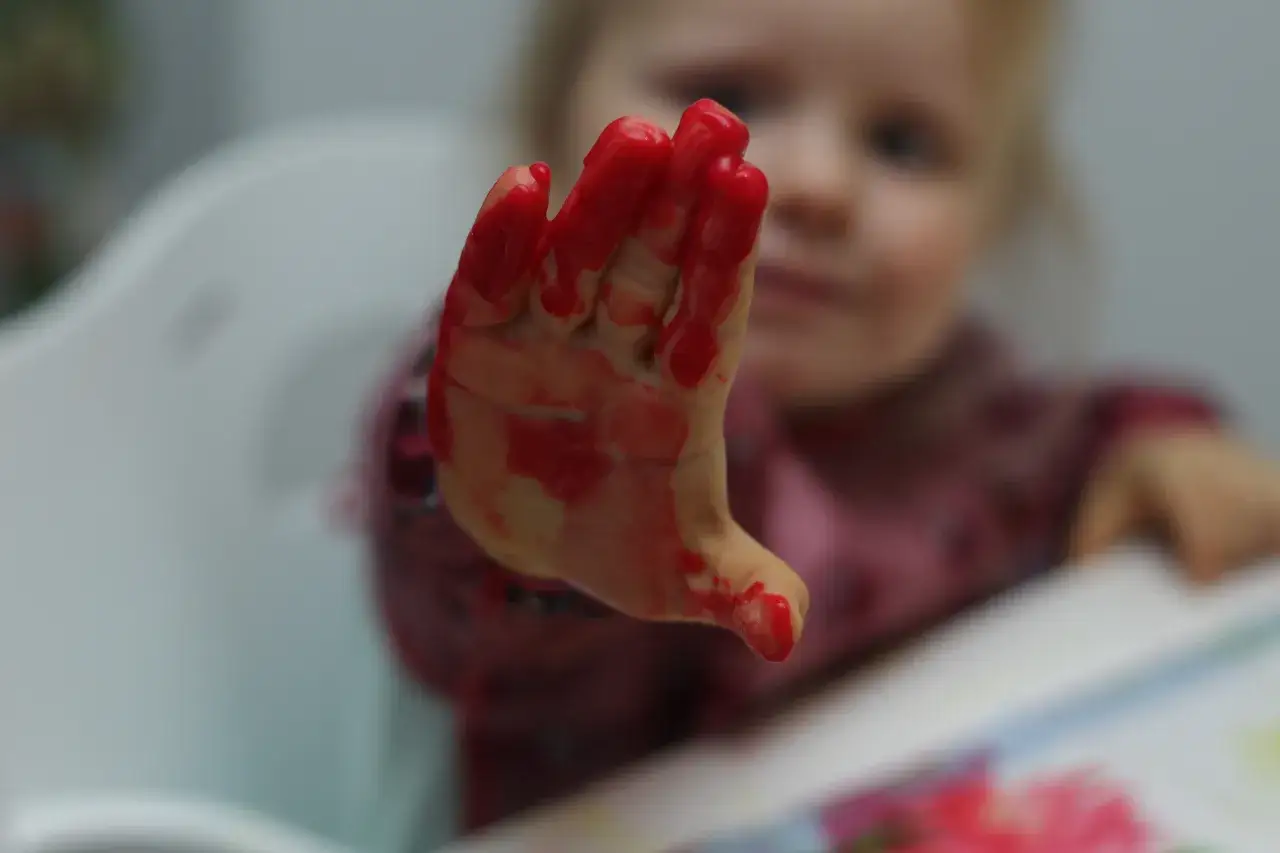 Dzieci malujące farbami palcami w żłobku