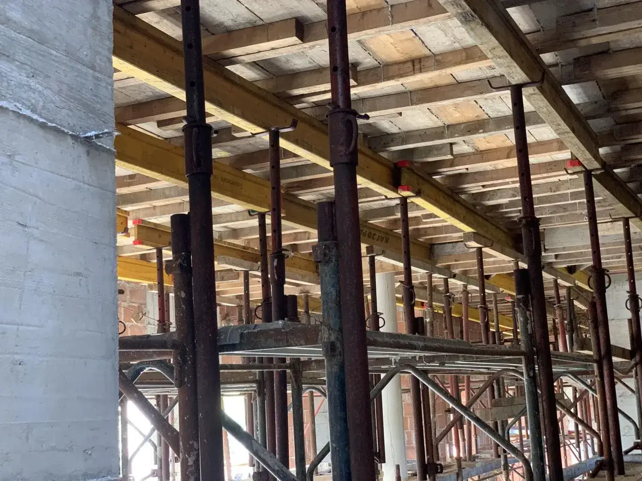 Rusztowanie pod strop, gotowe do wylania betonu. Widać drewniane deski i stalowe podpory.