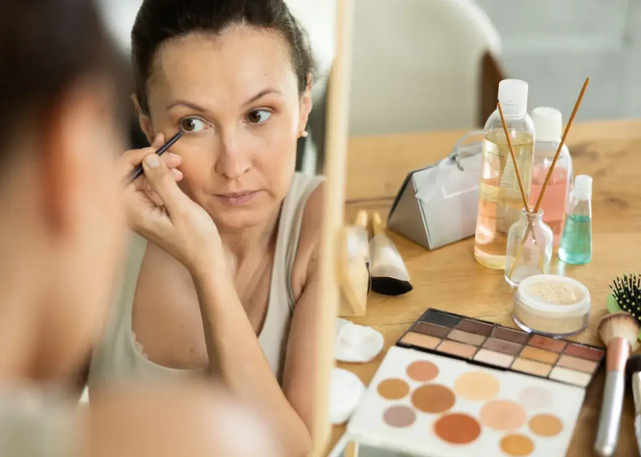kobieta nakładająca korektor pod oczy, przed i po makijażu