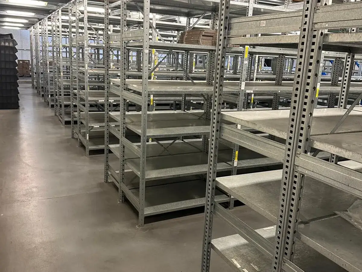 Pusty regał magazynowy, część projektu hali magazynowej. Metalowe półki czekają na towar.