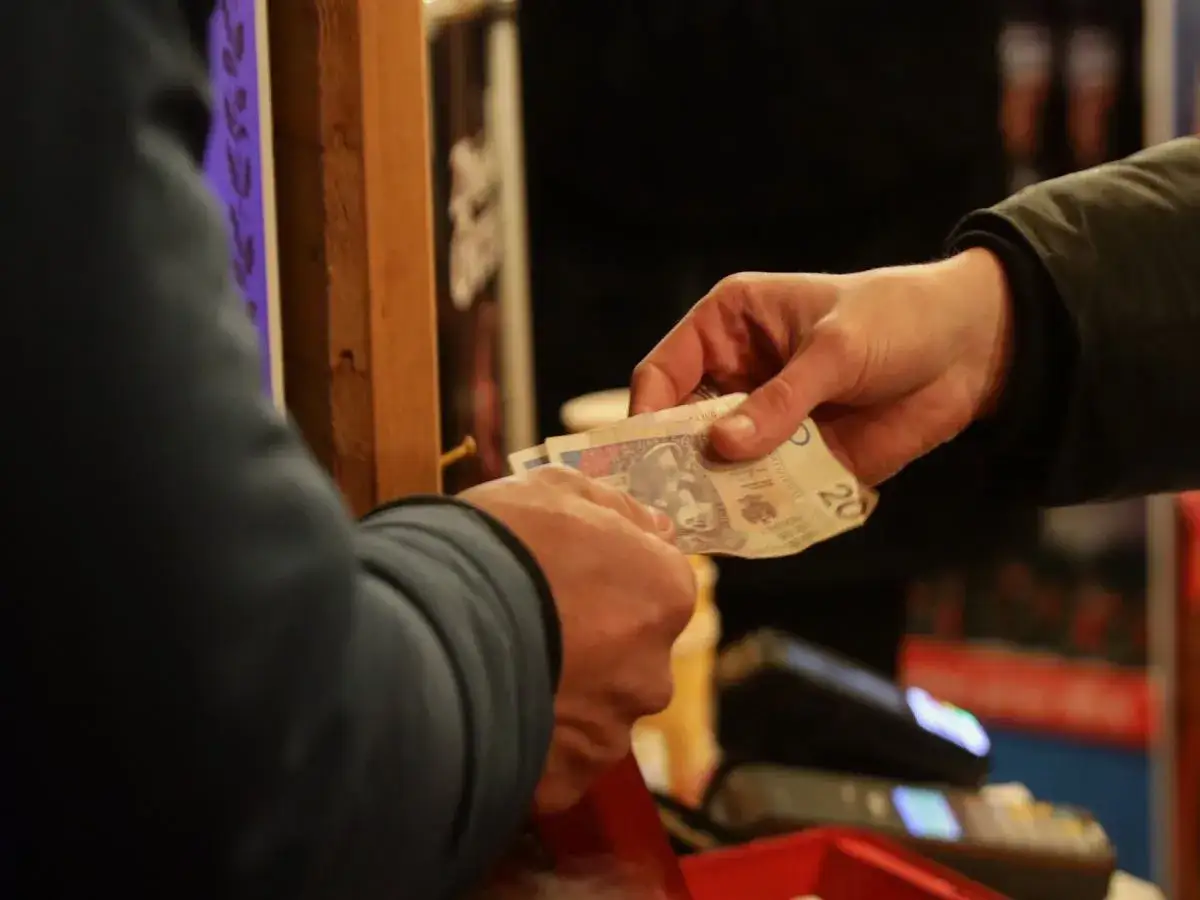 Ręce przekazują sobie pieniądze. To może być początek historii o tym, jak założyć lombard i zacząć biznes.