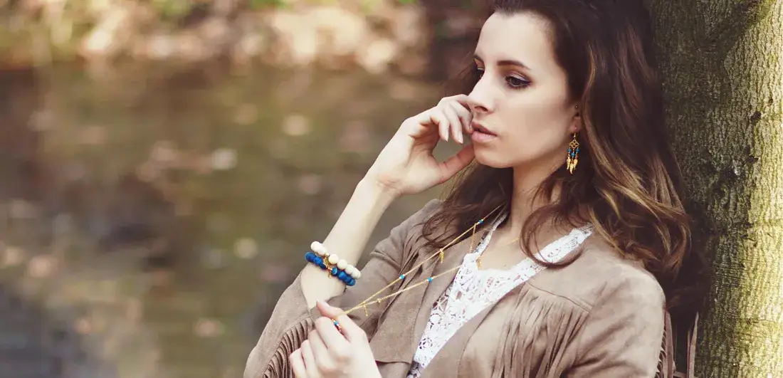 Kobieta w stylizacji boho, luźne ubrania, naturalne kolory, biżuteria