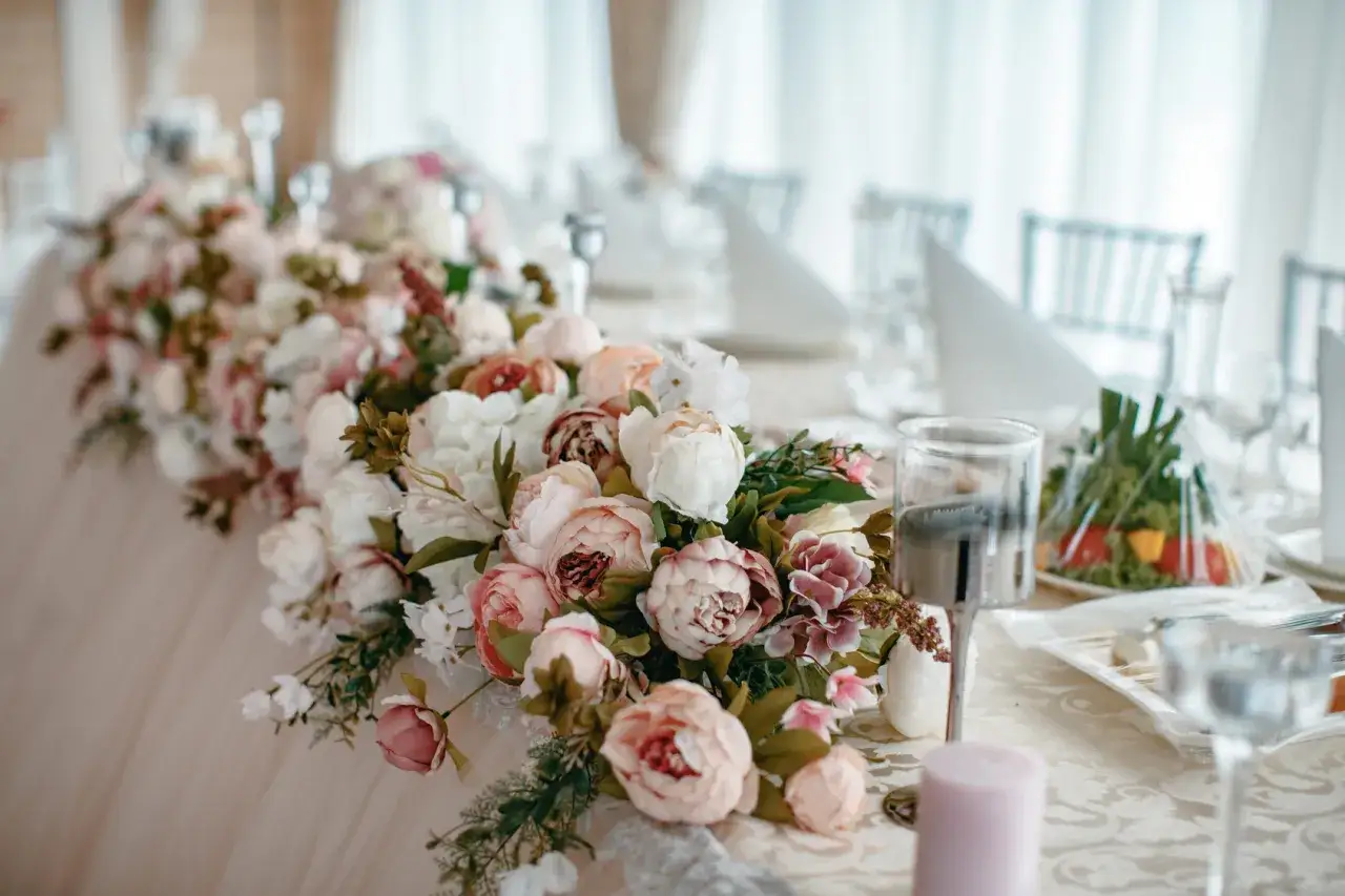 Piwonie na ślub tworzą romantyczną dekorację stołu. Delikatne kwiaty w pastelowych odcieniach, w towarzystwie zieleni, zapowiadają wyjątkową uroczystość.