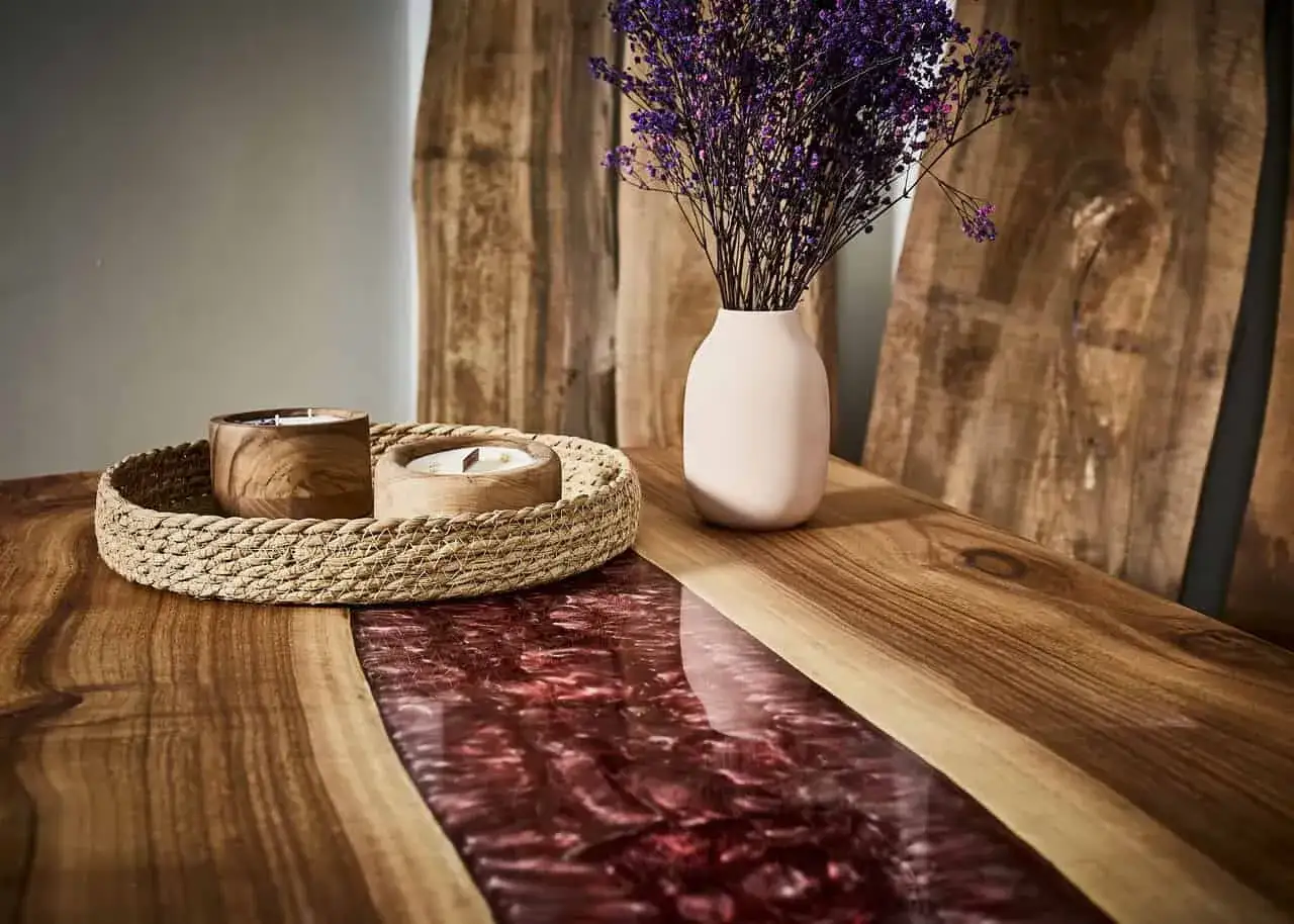 Stół z żywicy epoksydowej i drewna, z wazonem i świecami. Pokazuje, co można zrobić z żywicy epoksydowej, tworząc unikalne meble.