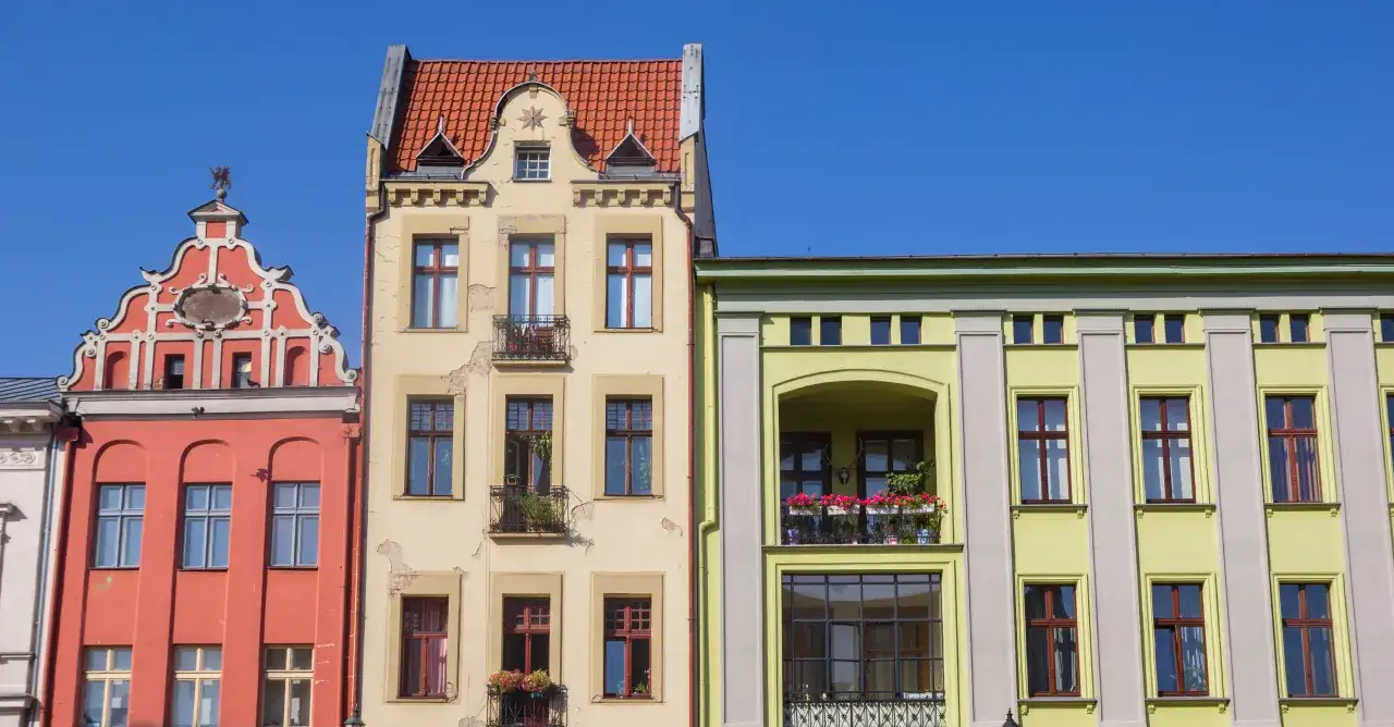 Kolorowe kamienice pod błękitnym niebem. Szukasz informacji, jak ustalić rok budowy domu? Spójrz na detale architektoniczne!
