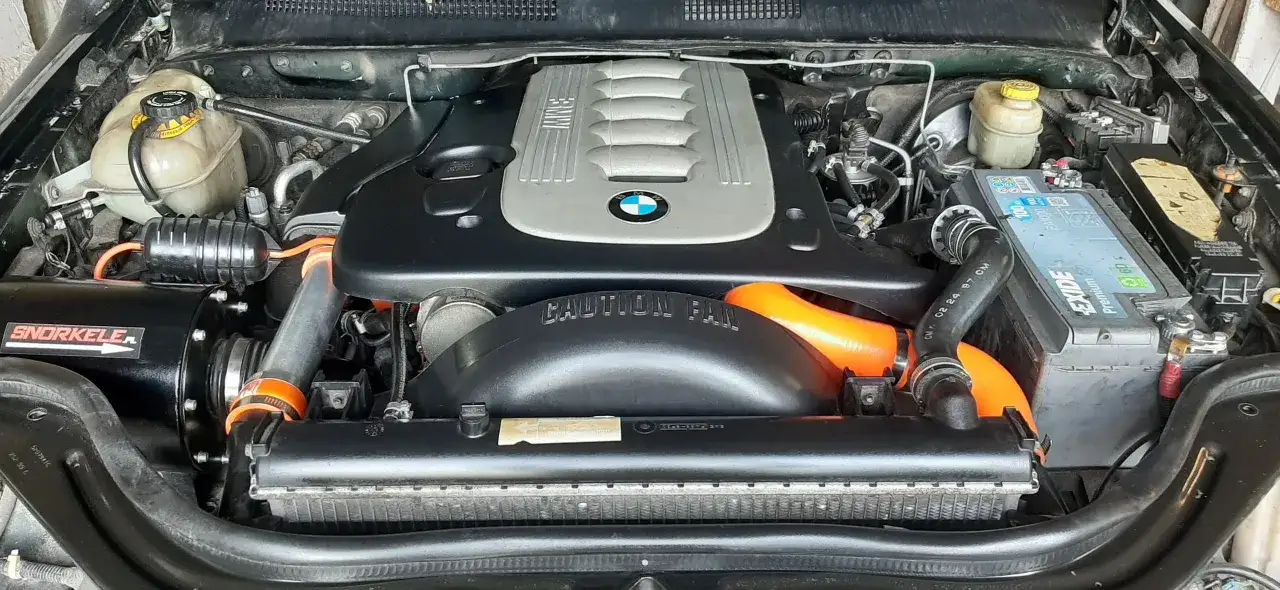 Silnik BMW E90 330d z pomarańczowymi wężami i czarnym snorkel'em.