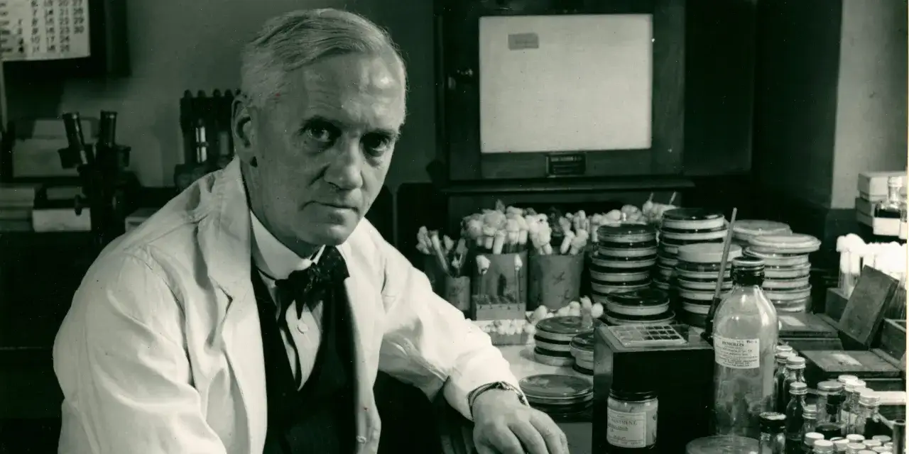 Alexander Fleming w swoim laboratorium, gdzie odkrył, jak wynaleziono penicylinę. Widać tu naczynia z kulturami bakterii i butelkę z napisem 