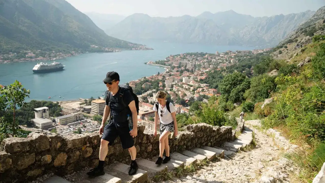 Spacerem po kamiennych schodach w Czarnog&oacute;rze, podziwiając zatokę i miasto. Czarnog&oacute;ra bez pośpiechu to idealny spos&oacute;b na odkrywanie takich widok&oacute;w.